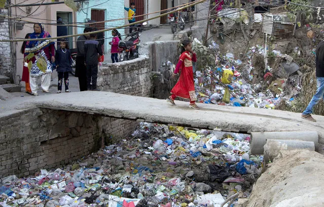 In this December 25, 2016, photo, a Pakistani Christian girl crosses a bridge in poor Christian neighborhood in Islamabad, Pakistan. Minorities in Muslim majority Pakistan seek equality in upcoming polls and a voice they say that will protect them against an increasingly intolerant and radical atmosphere that targets them. (Photo byB.K. Bangash/AP Photo)