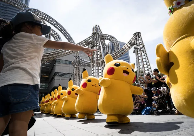 Performers dressed as Pikachu, a character from Pokemon series game titles, march during the Pikachu Outbreak event hosted by The Pokemon Co. on August 10, 2018 in Yokohama, Kanagawa, Japan. (Photo by Tomohiro Ohsumi/Getty Images)