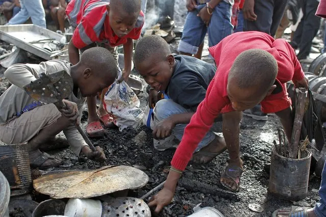 Children scavenge the charred remains of a market gutted overnight by a fire in the Petion-Ville suburb of Port-au-Prince, Haiti, Monday, November 21, 2016. After general elections ended Sunday night, a major fire ripped through the central market in the hillside district above the capital. The cause of the blaze was not immediately clear. (Photo by Ricardo Arduengo/AP Photo)