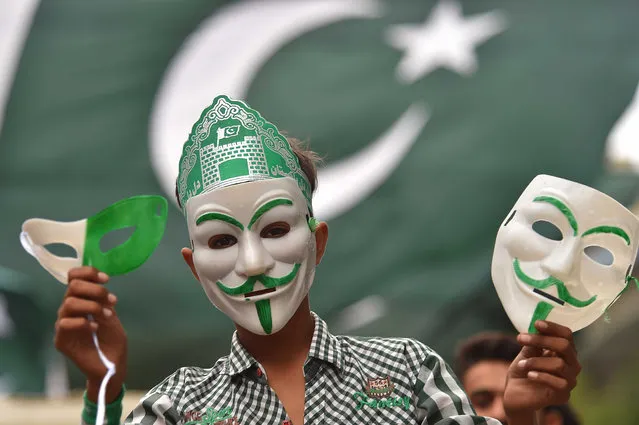 A Pakistani vendor sells decorative masks and items with colors of the national flag at a market as the nation prepares to celebrate Independence Day, in Karachi , Pakistan, 07 August 2023. Pakistan celebrates its 76th independence anniversary from British rule in 1947, on 14 August 2023. (Photo by Shahzaib Akber/EPA/EFE)