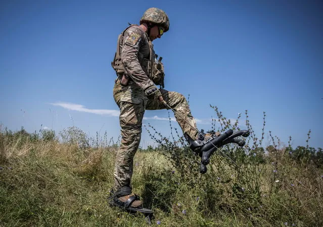 A sapper of 128th separate territorial defense brigade of the Armed Forces of Ukraine wearing “spider boots”, a protection system that prevents or minimises feet and legs injury, takes part in a training, amid Russia's attack on Ukraine, in Donetsk region, Ukraine on August 2, 2023. (Photo by Viacheslav Ratynskyi/Reuters)