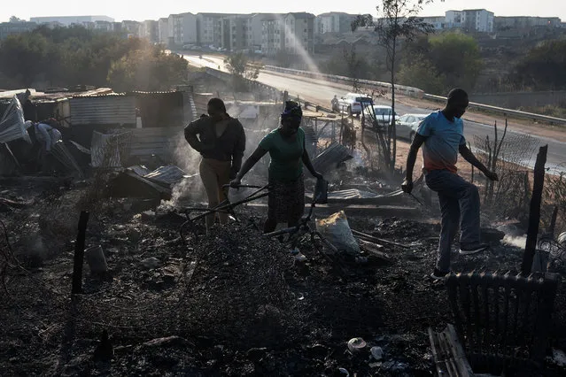 Residents rummage through the remains of their shack after a fire gutted an informal settlement in Fleurof, West of Johannesburg, South Africa in the early hours of September 3, 2023. (Photo by Shiraaz Mohamed/Reuters)