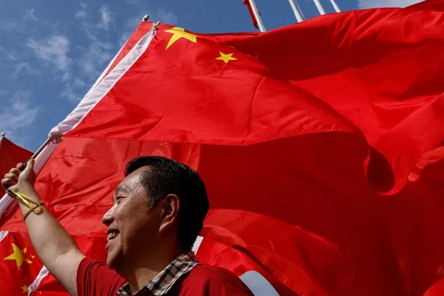 A pro-China supporter waves Chinese national flag to celebrate National Day in Hong Kong, China on October 1, 2023. (Photo by Tyrone Siu/Reuters)