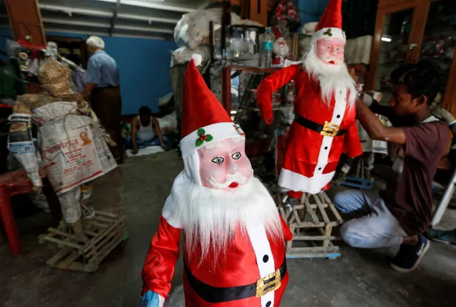 A worker gives finishing touches to a model of Santa Claus inside a workshop ahead of Christmas, in Kolkata, India, November 27, 2018. (Photo by Rupak De Chowdhuri/Reuters)