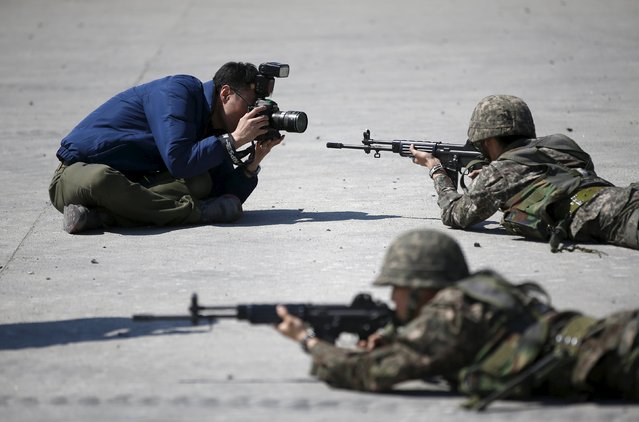 A photographer takes pictures of South Korean army soldiers taking part in a U.S.-South Korea joint live-fire military exercise at a training field in Pocheon, south of the demilitarized zone separating the two Koreas, March 25, 2015. The exercise is part of Foal Eagle, an annual military training between U.S. and South Korea that runs from March 2 to April 24. (Photo by Kim Hong-Ji/Reuters)