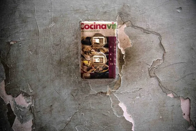 A makeshift light switch plate is decorated with an image of baked goods in the home of Yuliet Colon, a 39-year-old mother of two and a contributor to the Facebook page, “Recipes from the Heart” in Havana, Cuba, Friday, April 2, 2021. (Photo by Ramon Espinosa/AP Photo)