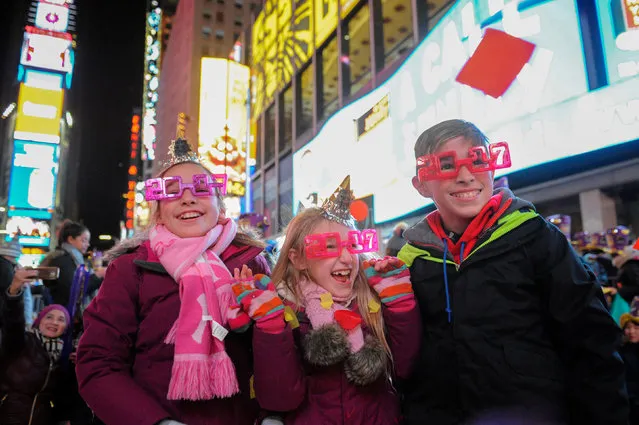 Children play with confetti to mark the new year in Times Square in New York, U.S. January 1, 2017. (Photo by Stephanie Keith/Reuters)