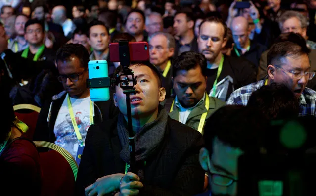 A showgoer uses two smartphones before the Nvidia keynote address at CES in Las Vegas, January 4, 2017. (Photo by Rick Wilking/Reuters)