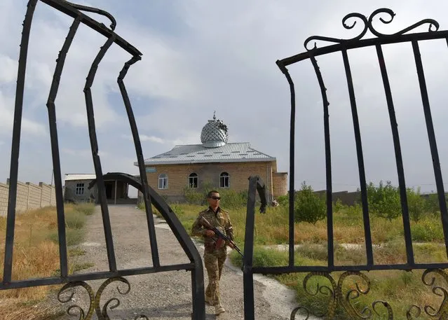 A Kyrgyz soldier patrols near a damaged mosque in the village of Maksat near the Kyrgyz-Tajik border, some 1200 kilometres from Bishkek, on September 20, 2022, as the worst violence the two ex-Soviet countries have seen in years broke out last week on their contested border, raising fears of a large-scale conflict. (Photo by Vyacheslav Oseledko/AFP Photo)