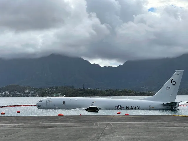 A Navy P-8A plane that overshot a runway at Marine Corps Base Hawaii and landed in shallow water offshore sits on a reef and sand in Kaneohe Bay, Hawaii, on Monday, November 27, 2023. The U.S. Navy said Monday that it has removed nearly all of the fuel from the large plane that landed in an environmentally sensitive bay, but it doesn't have a timetable for when it will get the aircraft out of the water. (Photo by Audrey McAvoy/AP Photo)