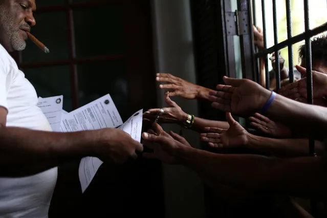 Followers of the Yoruba religion receive a sheet of paper with recommendations based on their annual predictions for the New Year, after a news conference in Havana, Cuba, January 3, 2017. (Photo by Alexandre Meneghini/Reuters)
