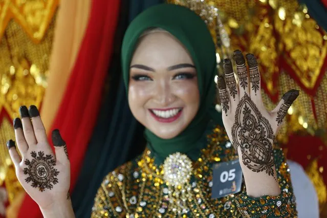 A model displays henna tattoo designs on her hands during a Henna tattoo competition in Banda Aceh, Indonesia, 07 November 2023. (Photo by Hotli Simanjuntak/EPA/EFE)
