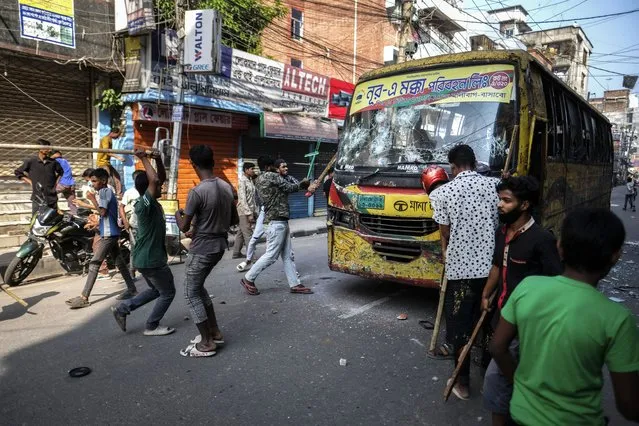 Bangladeshi garment workers vandalize buses during a protest demanding an increase in their wages at Mirpur in Dhaka, Bangladesh, Tuesday, October 31, 2023. (Photo by Mahmud Hossain Opu/AP Photo)