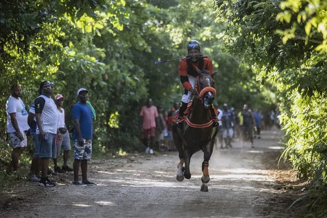 Race horse Chelsea finishes last, after race horse Dubai, in a two-horse race on San Andres Island in Colombia, Saturday, November 12, 2022. There’s no racetrack on the tiny Caribbean island of San Andres, but passion for horse racing runs deep. (Photo by Ivan Valencia/AP Photo)