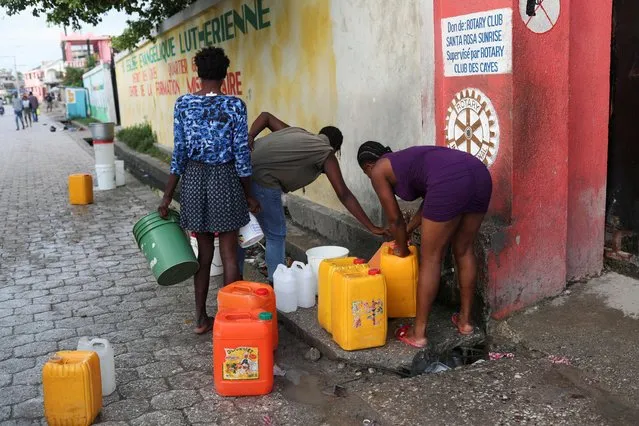 People collect water outside a stadium used as a shelter for residents who were evacuated from their damaged homes after Saturday's 7.2 magnitude quake, in Les Cayes, Haiti on August 18, 2021. (Photo by Henry Romero/Reuters)