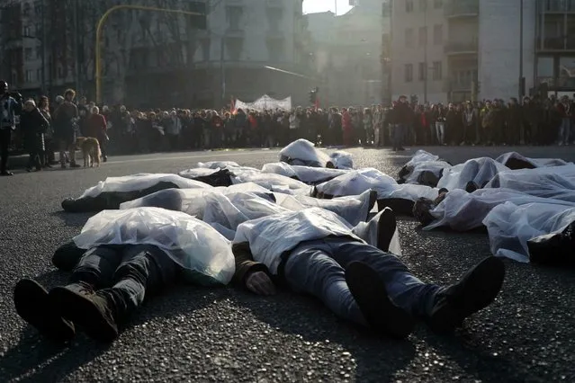 Activists lie on the ground as they take part in a protest against Italian Interior Minister Matteo Salvini's migrant and security decree, in Milan, Italy, Saturday, February 16, 2019. (Photo by Matteo Bazzi/ANSA via AP)