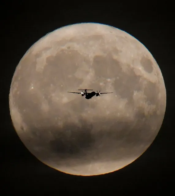 A passenger plane is seen with the full moon behind as it begins its final landing approach to Heathrow Airport in London, Britain, September 24, 2018. (Photo by Toby Melville/Reuters)