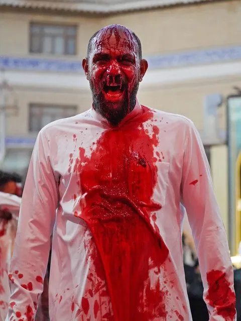 A man reacts after cutting his head to bleed in mourning with a knife as Shiite Muslims take part in mourning rituals on the day of Ashura, 10 Muharram according to the Islamic calendar commemorating the martyrdom of Prophet Mohammad's grandson Imam Hussein during the 7th century AD battle of Karbala, at the Imam Ali shrine in Iraq's central holy shrine city of Najaf early on August 19, 2021. (Photo by Ali Najafi/AFP Photo)