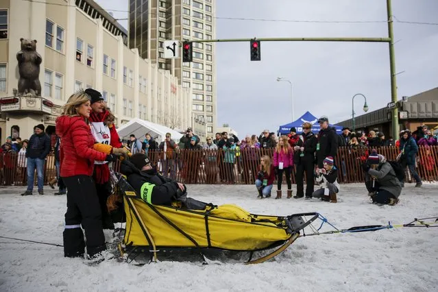 Two time champion Mitch Seavey waits with his wife and team at the ceremonial start of the Iditarod Trail Sled Dog Race to begin their near 1,000-mile (1,600-km) journey through Alaska’s frigid wilderness in downtown Anchorage, Alaska March 5, 2016. (Photo by Nathaniel Wilder/Reuters)