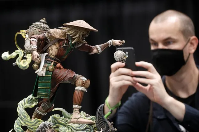 A man photographs merchandise during the 2021 New York Comic Con, at the Jacob Javits Convention Center in Manhattan in New York City, New York, U.S., October 7, 2021. (Photo by Brendan McDermid/Reuters)