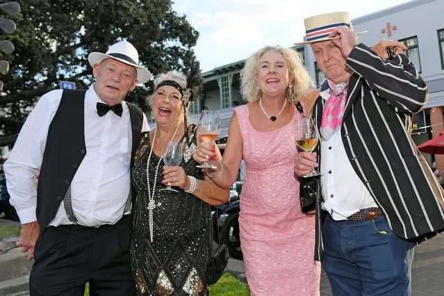 People in Art Deco costume pose for a photo on February 16, 2024 in Napier, New Zealand. The City of Napier celebrated the first official Art Deco weekend since COVID-19 and Cyclone Gabrielle caused cancellations. Cyclone Gabrielle, which hit Hawke's Bay between Feb. 12 and 16 in 2023, had a devastating impact causing extensive and widespread flooding due to rapidly rising rivers, resulting in a loss of life and significant damage to infrastructure and the environment. The region experienced a period of extreme devastation, with decimated residential and commercial areas, leaving over 70,000 residents without essential services and connectivity, and resulting in long-term effects that are still being felt across the community. (Photo by Kerry Marshall/Getty Images)
