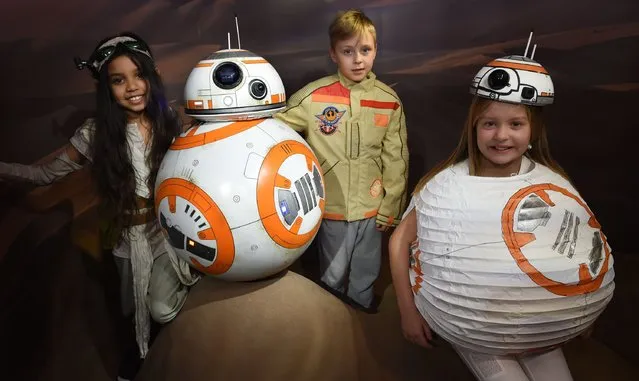 Star Wars fans pose with the new BB8 figure unveiled at Madame Tussauds London on March 21, 2016 in London, United Kingdom. (Photo by Stuart C. Wilson/Getty Images)