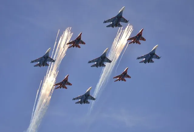 Sukhoi Su-27 Flanker fighters of the Russian Knights aerobatic display team and Mikoyan-Gurevich MiG-29 Fulcrum fighters of the Swifts aerobatic display team fly in formation over the Red Square during the Victory Day parade in Moscow, Russia, May 9, 2015. (Photo by Reuters/Host Photo Agency/RIA Novosti)