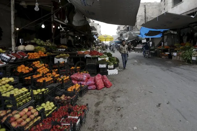 Residents walk through a vegetable market in the town of Marat Numan in Idlib province, Syria March 24, 2016. (Photo by Khalil Ashawi/Reuters)