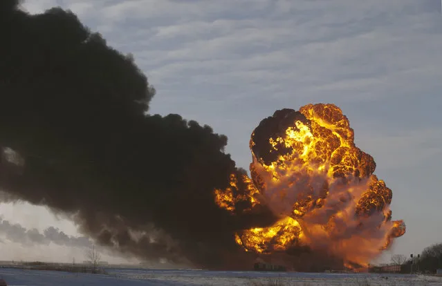 In this December 30, 2013 file photo, a fireball goes up at the site of an oil train derailment in Casselton, N.D.  On Tuesday, March 31, 2015, Bryan Thompson, of Fargo, N.D., the engineer of the oil tanker train involved in the derailment, filed a complaint against BNSF Railway, accusing the railroad of negligence. (Photo by Bruce Crummy/AP Photo)