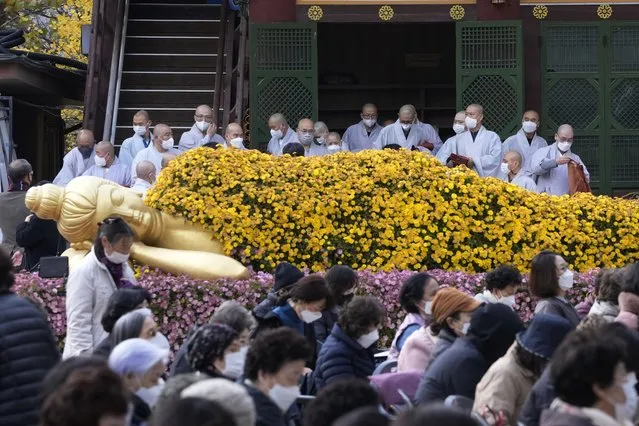 Buddhists monks wearing face masks as a precaution against the coronavirus leave a hall at the Jogyesa Buddhist temple in Seoul, South Korea, Wednesday, November 17, 2021. South Korea on Wednesday reported 3,187 new cases of the coronavirus, nearly matching a one-day record set in September, a worrisome development in a country that eased social distancing rules in recent weeks to lessen the pandemic's economic impact. (Photo by Ahn Young-joon/AP Photo)