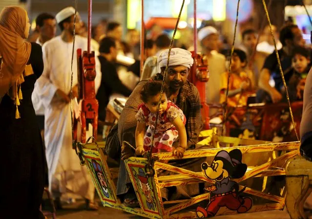 A father and his daughter rides a swing as people celebrate the birthday of Sayida Zeinab, the granddaughter of Prophet Mohammad, near her shrine in Cairo, May 13, 2015. (Photo by Mohamed Abd El Ghany/Reuters)