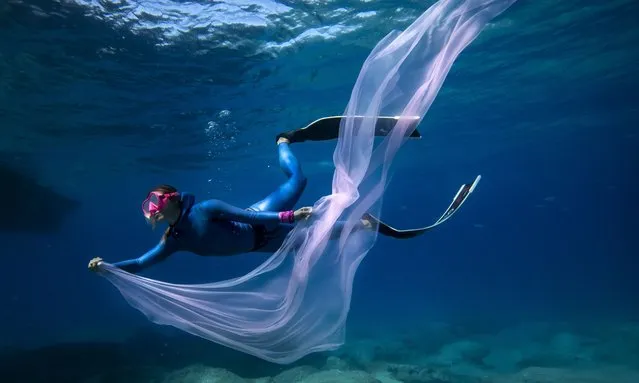 Turkey's multiple world record holder and free diver, Sahika Ercumen wears a pink tulle on her wrist as she dives with women battling breast cancer to raise awareness about breast cancer with the “Pi Women's Cancer Society”, in Antalya, Turkey on October 25, 2021. During the dive, participants wore pink tulles on their wrists, pink ribbons on their scuba diving equipment, and pink and purple diving masks. Sahika Ercumen tomorrow will attempt to break men's and women's world record in 100 meters freediving on a single breath in commemoration of the 98th anniversary of Republic Day of Turkey. (Photo by Sebnem Coskun/Anadolu Agency via Getty Images)