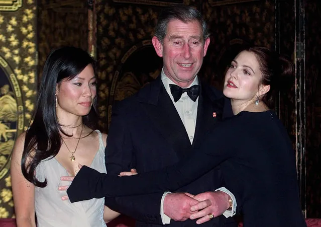 The Prince of Wales, flanked by Lucy Liu, (left) as Drew Barrymore (right) hits Liu in an attempt to give Prince Charles a hug prior to a dinner at St. James's Palace in London on November 21, 2000. Prince Charles hosted a dinner ahead of the Prince's Trust premiere of “Charlie's Angels” in London.   (Photo by PA Images via Getty Images)