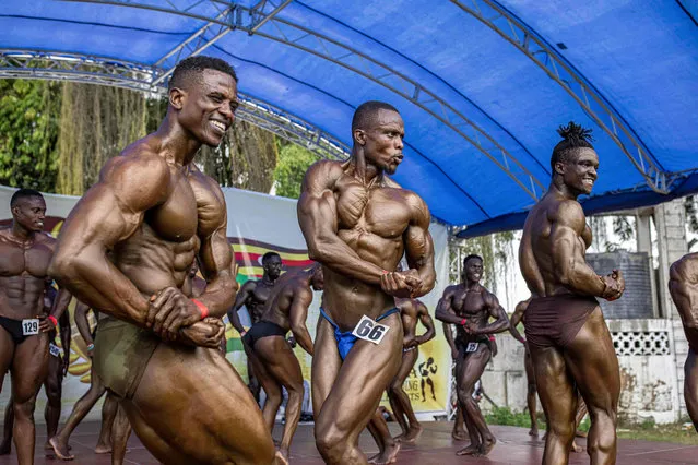 Bodybuilders pose on stage during the Mr.001 bodybuilding competition in Mombasa, Kenya, on December 11, 2021. This bodybuilding competition was created by a former bodybuilder and its the first one to happen in the coastal city since 2015. The name comes from Mombasa's county code and currently is considered one of the biggest in East and Central Africa. The first edition brought over 200 participants from Kenya, Uganda, Tanzania, Nigeria, South Africa and Pakistan who competed in different categories including physique, bikini and figure. (Photo by Patrick Meinhardt/AFP Photo)