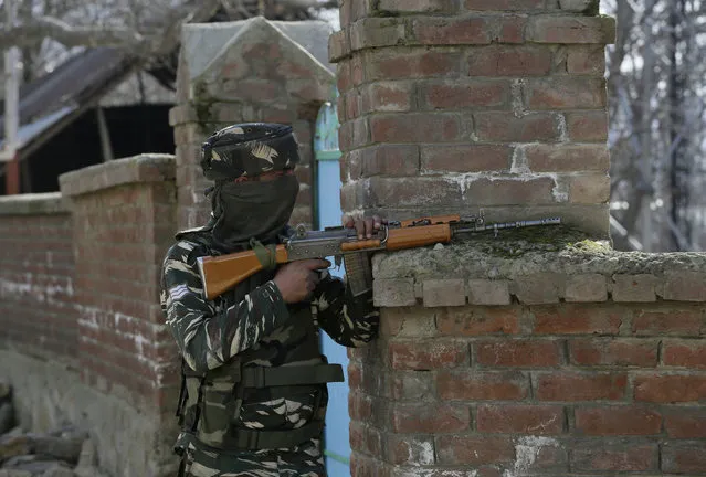 A government security person takes position during a gun-battle at Haffo village, 43 Kilometers (27 miles) south of Srinagar, India, Sunday, March 5, 2017. Anti-India protests erupted in Indian-controlled Kashmir following a fierce gunbattle in which two rebels and a counterinsurgency policeman have been killed, police said Sunday. (Photo by Mukhtar Khan/AP Photo)