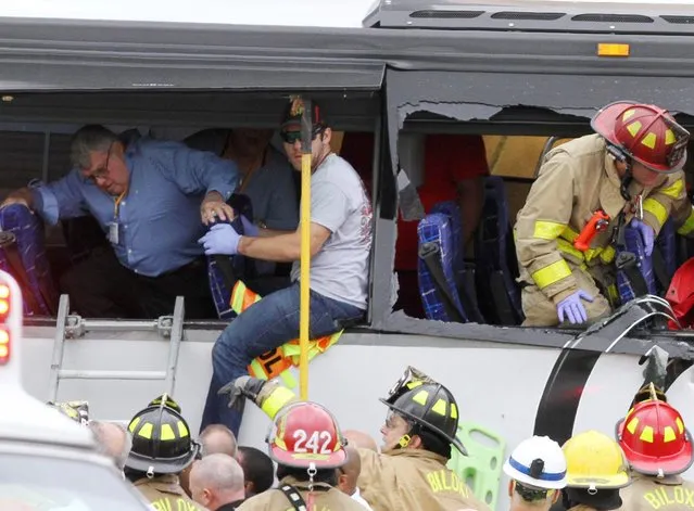 Rescue personnel work to remove passengers from a charter bus that was hit by a CSX train at the Main Street crossing in Biloxi, Miss., on Tuesday, March 7, 2017. (Photo by John Fitzhugh/The Sun Herald via AP Photo)