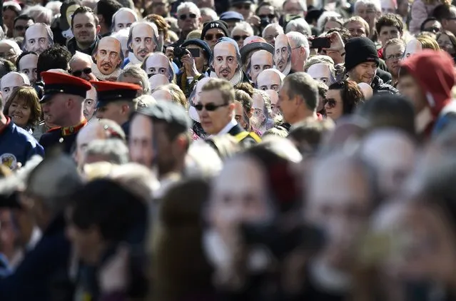 People hold up face masks with William Shakespeare's portrait during celebrations to mark the 400th anniversary of the playwright's death in the city of his birth, Stratford-Upon-Avon, Britain, April 23, 2016. (Photo by Dylan Martinez/Reuters)