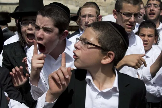Ultra-Orthodox Jewish youth yell at a journalist covering the Jewish women's prayer during the Jewish holiday of Passover in front of the Western Wall, the holiest site where Jews can pray, in Jerusalem's Old City, April 24, 2016. A liberal women's group has held a special Passover prayer service at a Jerusalem holy site, drawing criticism from the site's ultra-Orthodox rabbi, who called it a “provocation”. (Photo by Ariel Schalit/AP Photo)