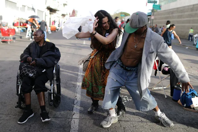 Iranian American volunteer Marjan Vayghan, 32, (C) dances with people on Skid Row after serving food to homeless people to celebrate Nowruz, Iranian New Year, in Los Angeles, California, U.S., March 17, 2017. (Photo by Lucy Nicholson/Reuters)
