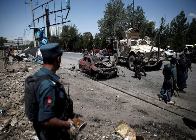 An Afghan policeman keeps watch at the site of a suicide bomb attack in Kabul, Afghanistan June 30, 2015. (Photo by Ahmad Masood/Reuters)