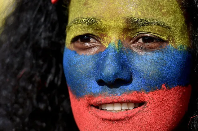 A woman with her face painted in the colors of the Colombian flag takes part in a protest against a tax reform bill they say will leave them poorer as the country battles its deadliest phase yet of the coronavirus pandemic, in Cali, Colombia, on May 1, 2021. Colombian President Ivan Duque caved in on April 30 to widespread anger and said he would overhaul the proposed tax reform. Duque announced he was shelving clauses that would lower the income tax threshold to broaden the tax base and raise value-added taxes on goods and services. (Photo by Luis Robayo/AFP Photo)