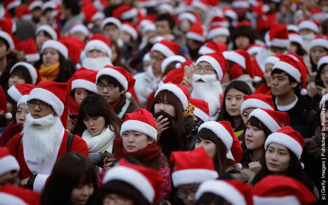 South Koreans wear Santa Claus outfits and hold gifts to promote Christmas at a charity event