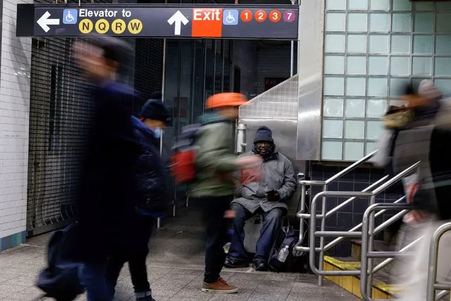 A homeless charges his mobile devise inside the subway station in New York, U.S., February 19, 2022. (Photo by Eduardo Munoz/Reuters)