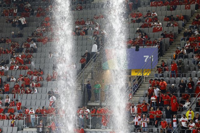 Water pours through the roof and onto the stadium seats after heavy rain ahead of the 2024 European Football Championship (EURO 2024) Group F football match between Turkiye and Georgia at BVB Stadion Dortmund in Dortmund, Germany on June 18, 2024. (Photo by Leon Kuegeler/Reuters)