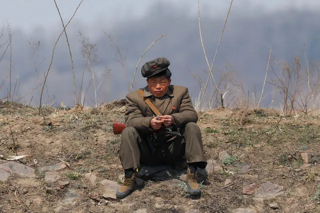 A North Korean soldier sits on a bank of the Yalu River just north of Sinuiju, North Korea, April 2, 2017. (Photo by Damir Sagolj/Reuters)