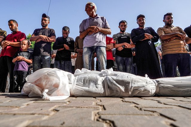 Mourners pray by the body of Abdelrahman Youssef Abu Galambo, an 11-year-old child who died during Israeli bombardment in al-Bureij in the central Gaza Strip and was later transported to the Aqsa Martyrs hospital in Deir el-Balah on June 14, 2024 amid the ongoing conflict in the Palestinian territory between Israel and Hamas. (Photo by Bashar Taleb/AFP Photo)