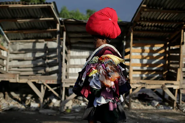 A street vendor carries her goods as she walks in a market in Port-au-Prince, Haiti, February 14, 2017. (Photo by Andres Martinez Casares/Reuters)