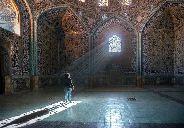 A man stands in the light of a geometric window in a mosque, taken in Iran, November 2016. A photographer spent a month exploring Iran to understand the science and mathematics behind divine beauty of Islamic buildings. After reading an article about the use of specific ratios and geometry in Persian architecture, Massimo Rumi was fixated on the idea of travelling from his home country of Italy to Iran. Massimo said: “I was fascinated by the spirituality and wisdom behind it”. The article was talking about the use of specific ratios, found in nature in the design of life forms, to reflect “divine beauty” in the Islamic building. Massimo took his trip in November 2016 and only intended it to be 10 days long, however the ease of travel in Iran and friendliness of the locals, made him choose to stay longer. (Photo by Massimo Rumi/Barcroft Images)