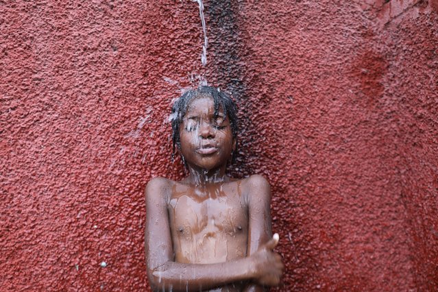 A boy showers at the Ecole Nationale Joseph C. Bernard de Freres where he and others are taking shelter after they had to flee their homes due to gang violence, in Port-au-Prince, Haiti on May 22, 2024. (Photo by Ralph Tedy Erol/Reuters)