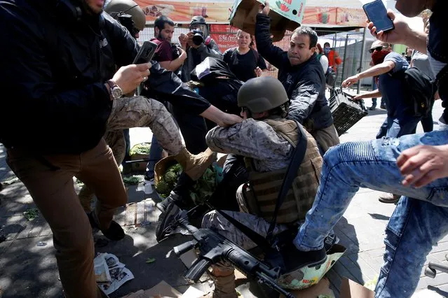 Demonstrators clash with a member of the security forces during a protest against Chile's state economic model in Valparaiso, Chile, October 21, 2019. Santiago and other Chilean cities have been engulfed by several days of rioting as protests over an increase in public transport costs prompted President Sebastian Pinera to declare a state of emergency. (Photo by Rodrigo Garrido/Reuters)